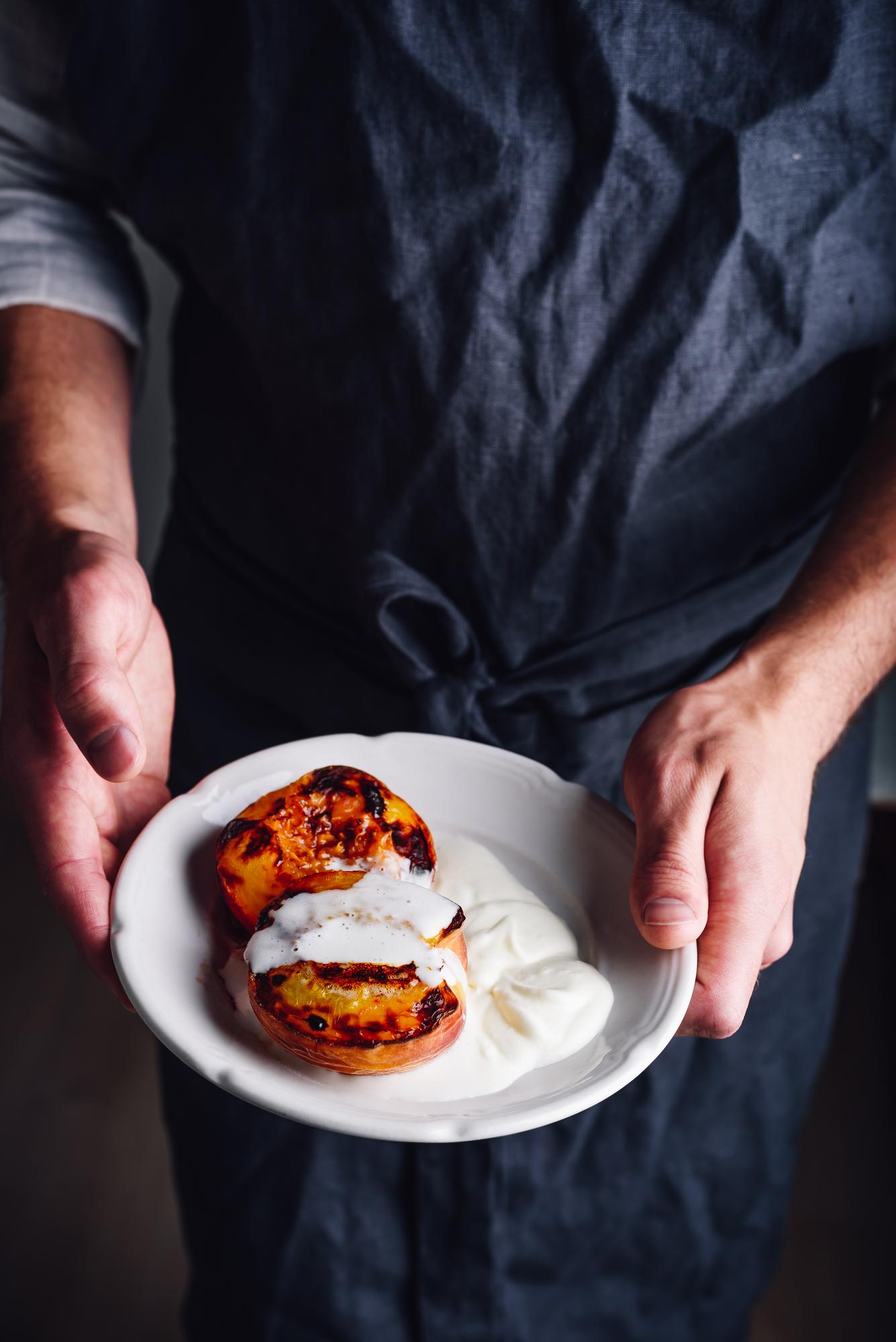 Chef arranging plated gourmet dish on dark table